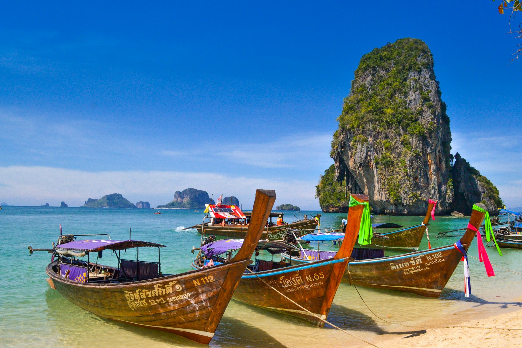 Plage de Railay en Thaïlande avec bateaux longtail